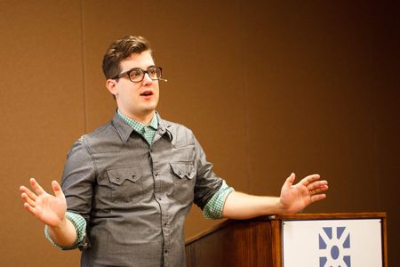 Speaking at a conference with arms wide