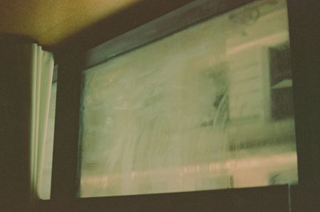 A window in a hotel room all smudged and fogged up.