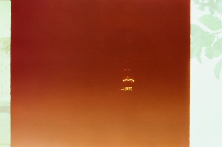 An abstract image with the faint glow of a lightbulb emerging through the murk.