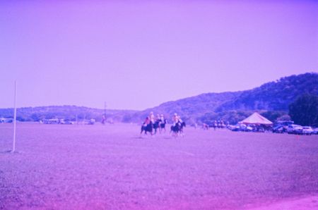 Some Texans play polo in a field in Hill Country.