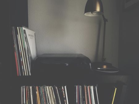 A turntable sitting on shelves filled with records.